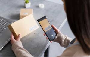 high-angle-woman-scanning-bar-code-box-with-smarphone_23-2148567249 1